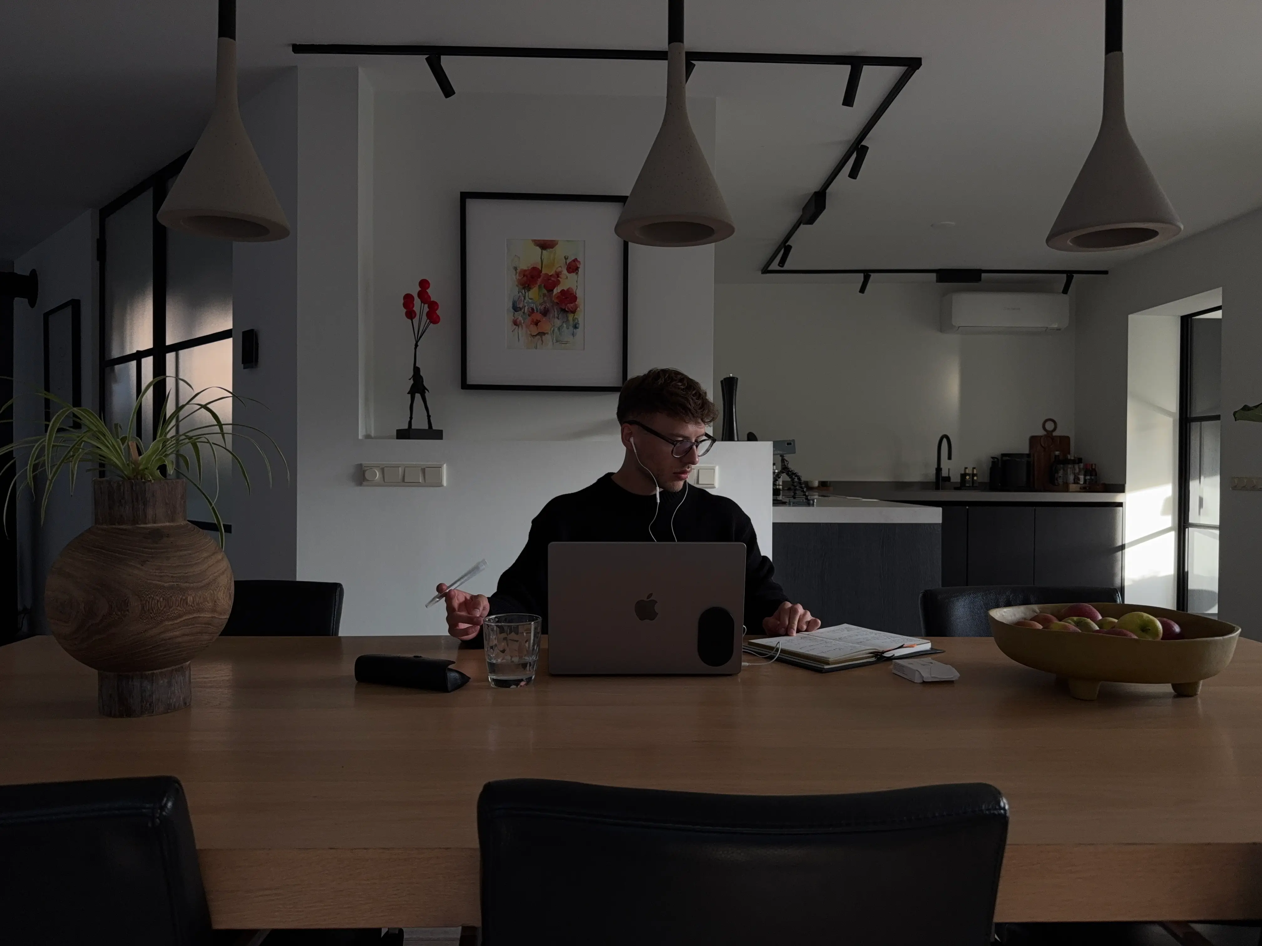 Daan at his monitor with earphones in, on a call.